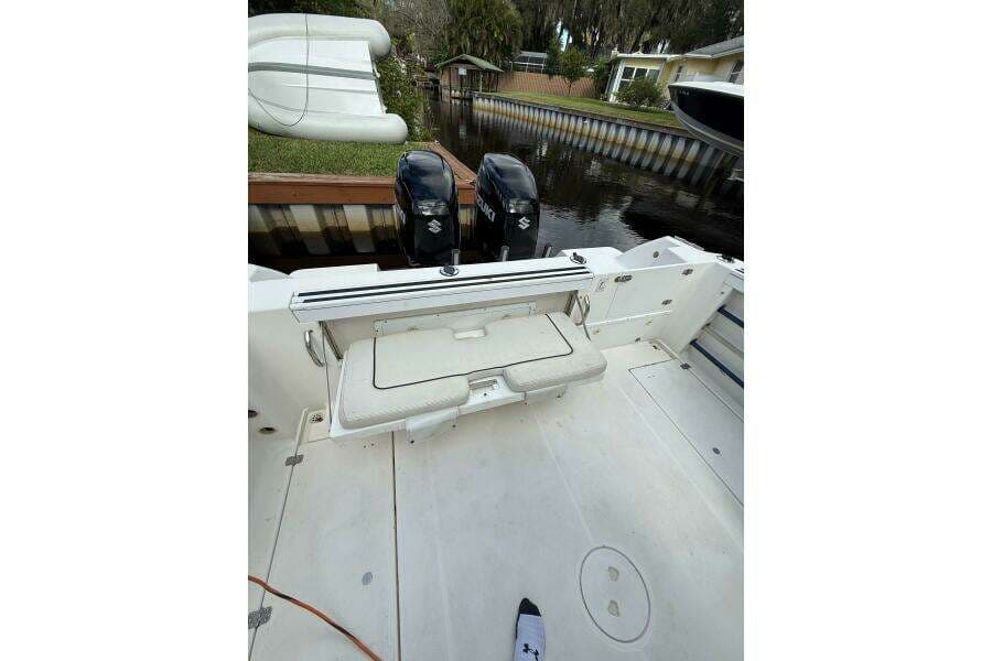 2002 Wellcraft 290 Coastal boat interior with dual outboard motors, docked by a canal.