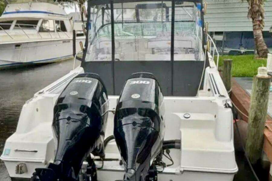 2002 Wellcraft 290 Coastal boat with dual outboard engines docked at marina.