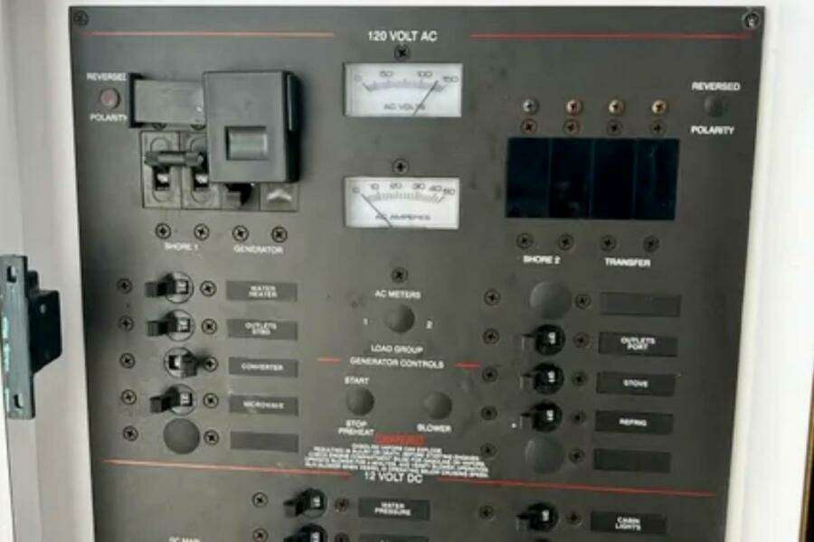Electrical control panel on a 2002 Wellcraft 290 Coastal boat, featuring various switches and meters.